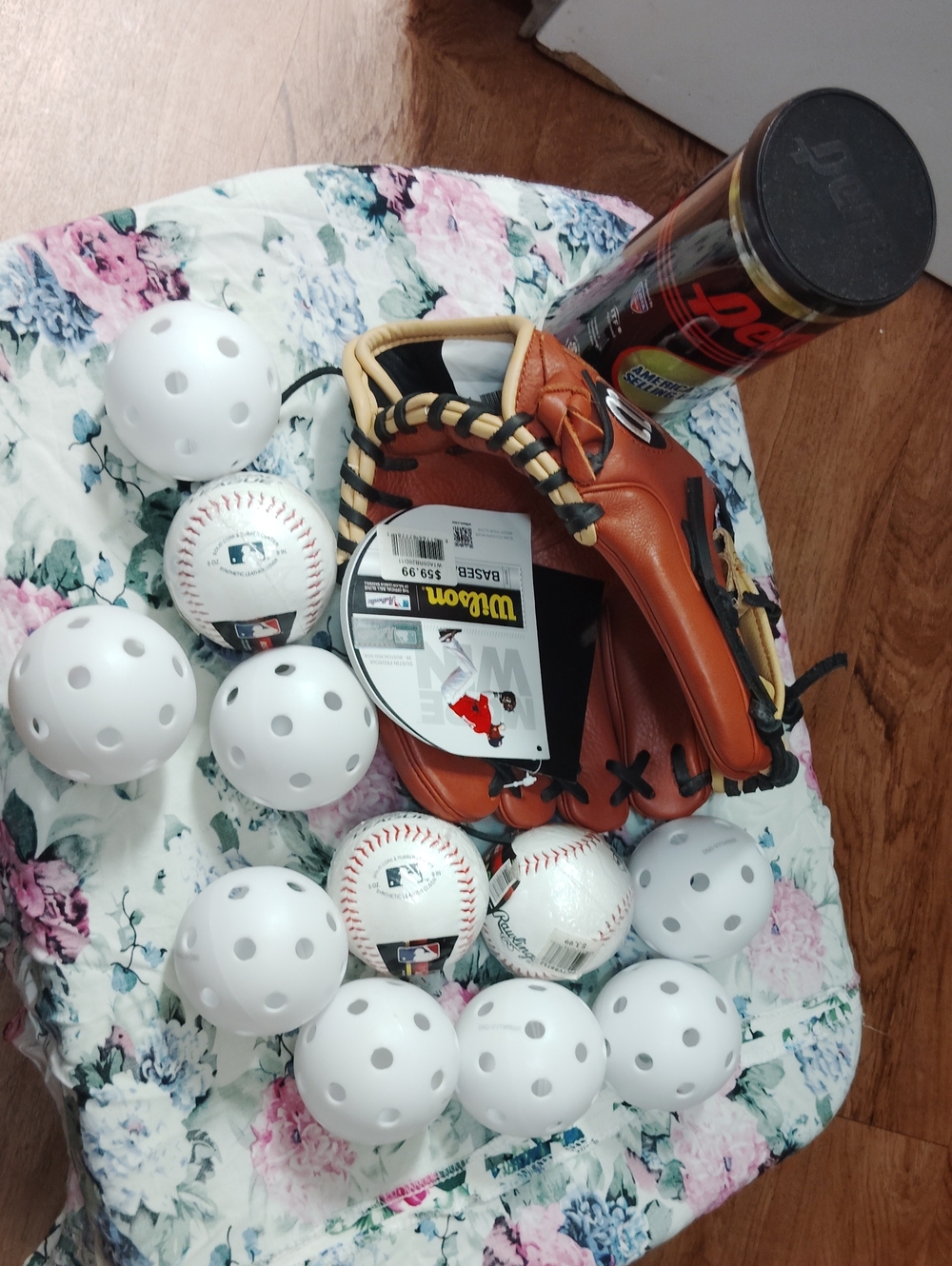 Wilson tan and black leather baseball glove with white practice balls
